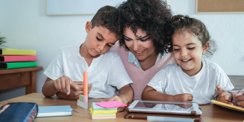 teacher-using-tablet-with-children-in-kindergarten-school-focus-on-girl-face.jpg